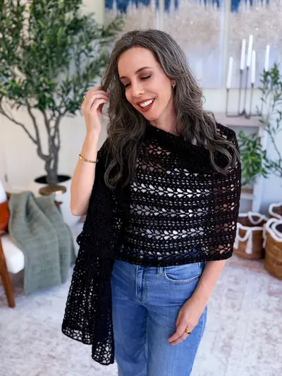 Woman wearing the black Willow Mesh Crochet Wrap with jeans