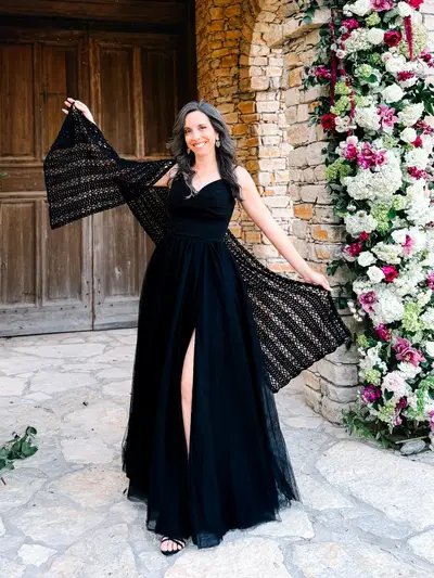 Woman in a black gown wearing the Willow Mesh Crochet Wrap outdoors