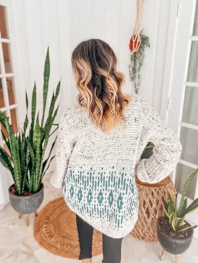Back of the cream cardigan with a teal mosaic star band at the hem