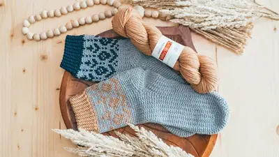 Pair of Woodland Walker Crochet Socks in light blue on a wooden tray